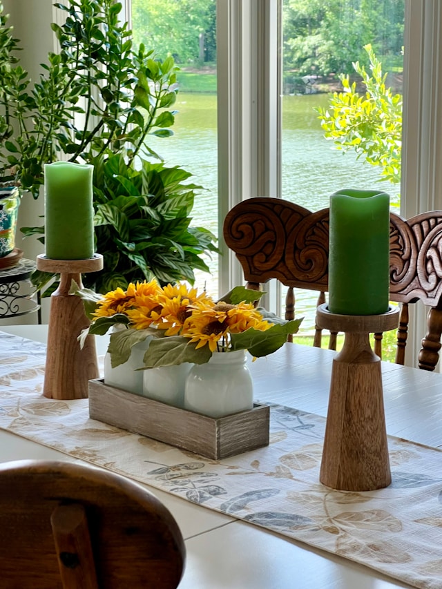 A modern dining room centerpiece featuring a large glass bowl filled with floating candles, surrounded by smaller glass votive holders and decorative glass spheres