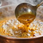 Copper kadhai with food being cooked
