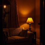 An evening interior shot a living room glowing warmly from three different light sources — a dimmable pendant, two table lamps on either side of the sofa, and a floor lamp in the corner. Rich, war