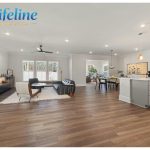 Open-plan small house interior showing kitchen, dining, and living area flowing seamlessly