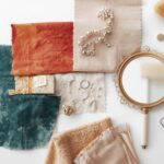 A mood board style flat-lay showing MIPIMPROV essentials — a paint swatch, fabric samples, a mirror, and simple accessories. Styled on a white background.