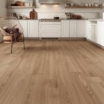 A warm, inviting kitchen interior featuring luxury vinyl plank flooring in a medium oak tone, with open shelving and white cabinetry above, demonstrating the realistic wood-look aesthetic.