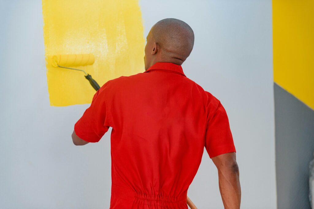 Painting a room wall with roller and brush