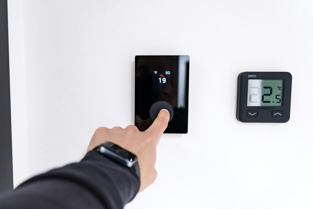  Programmable thermostat being adjusted on wall