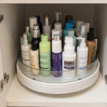 A lazy Susan turntable filled with skincare bottles inside a compact bathroom cabinet, demonstrating an easy-access small-space hack.